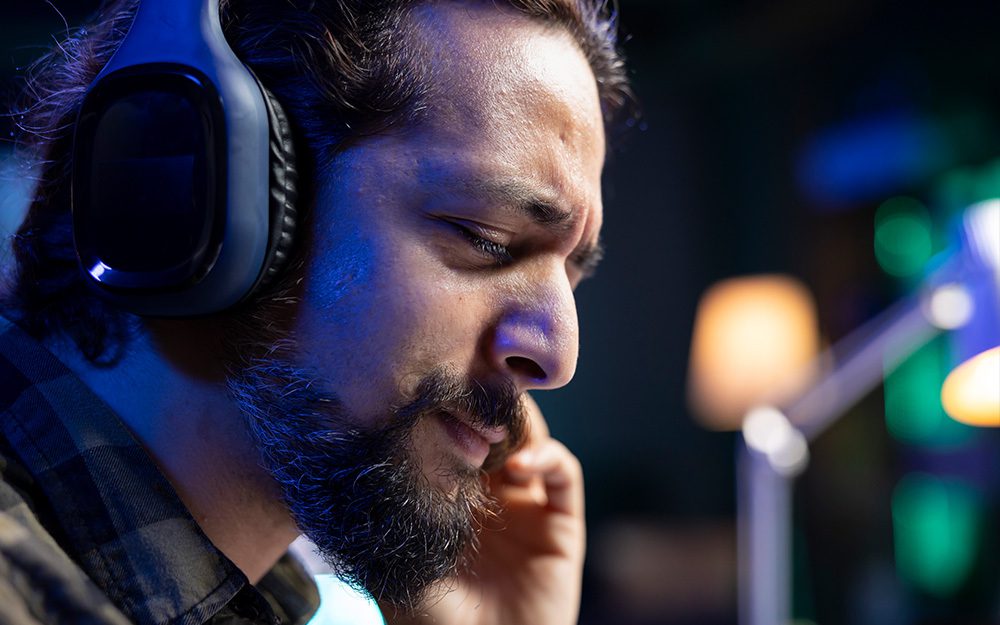 Image shows a man listening to headphones.