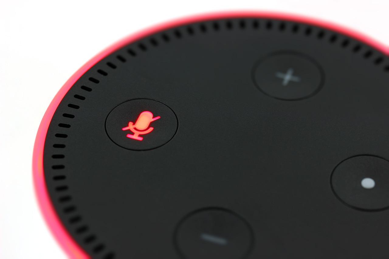 Image is a close up of the top of an Amazon Echo speaker, with the mute button turned on.