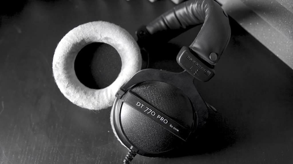 This is a black and white image of some headphones. One of the earcups is exposed to the camera, white, while the rest of the headphoens are black.