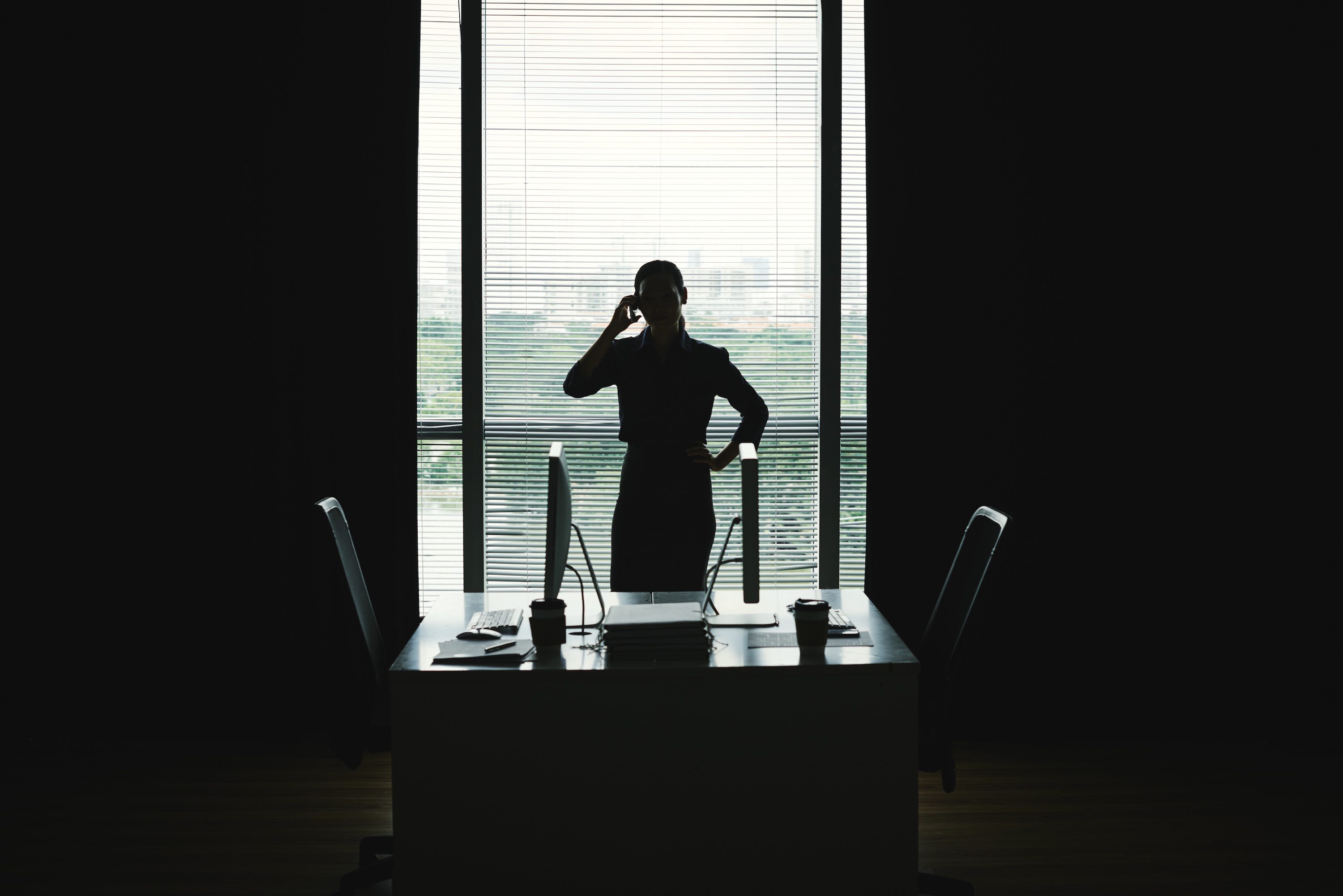 Calling Business Lady In Front of backlit office window