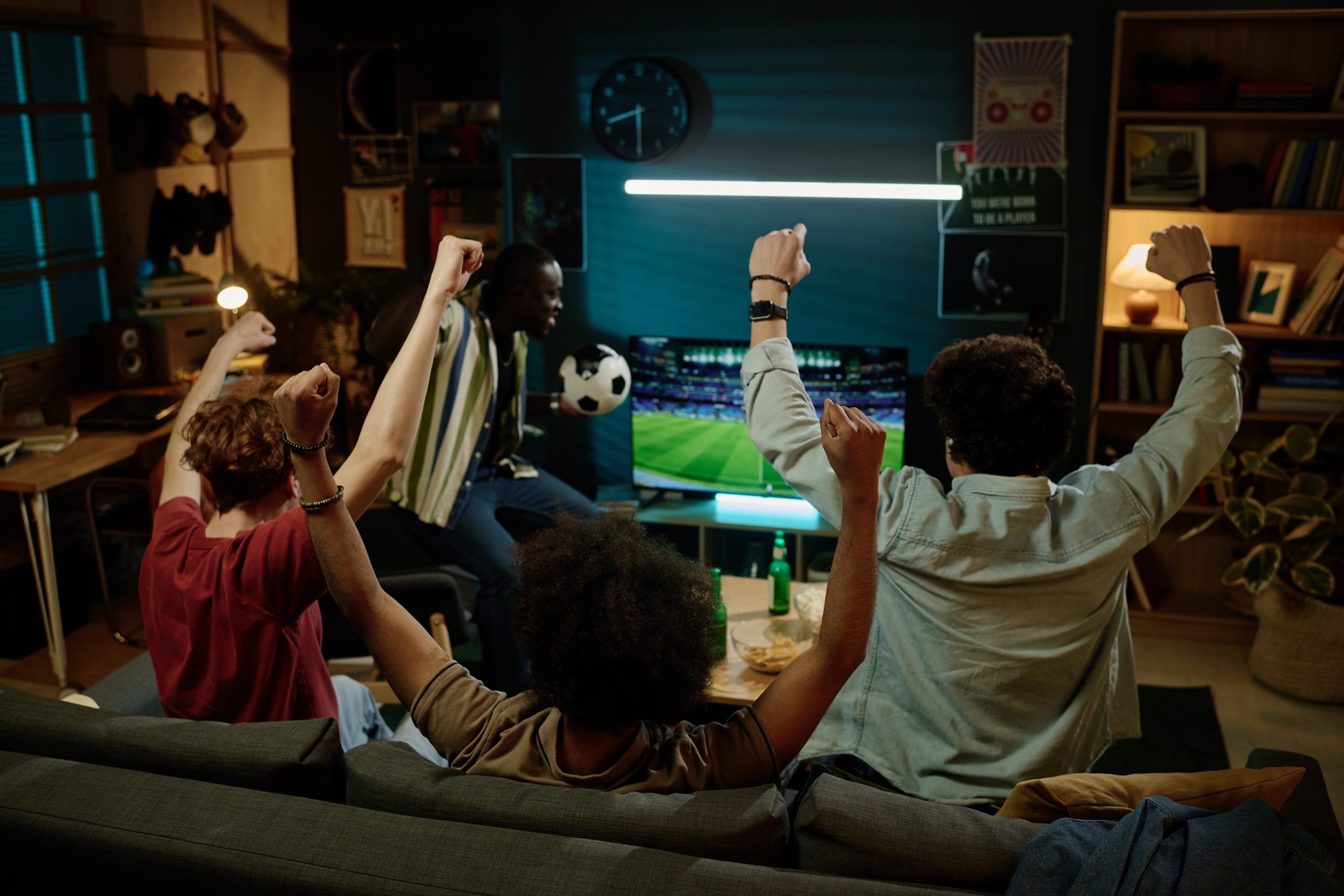 Group of friends watching football on the television