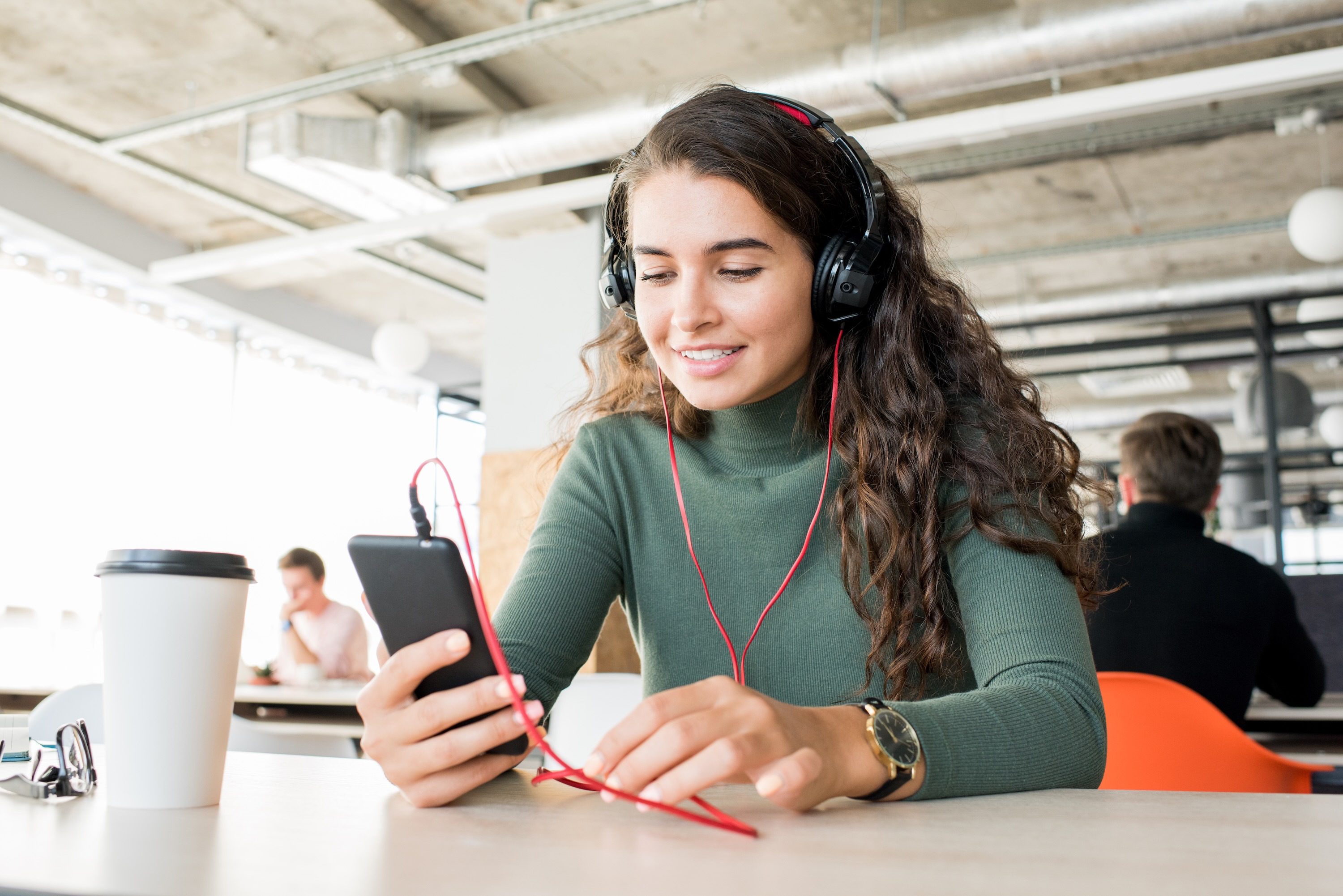 Woman listening to radio broadcast at cafe