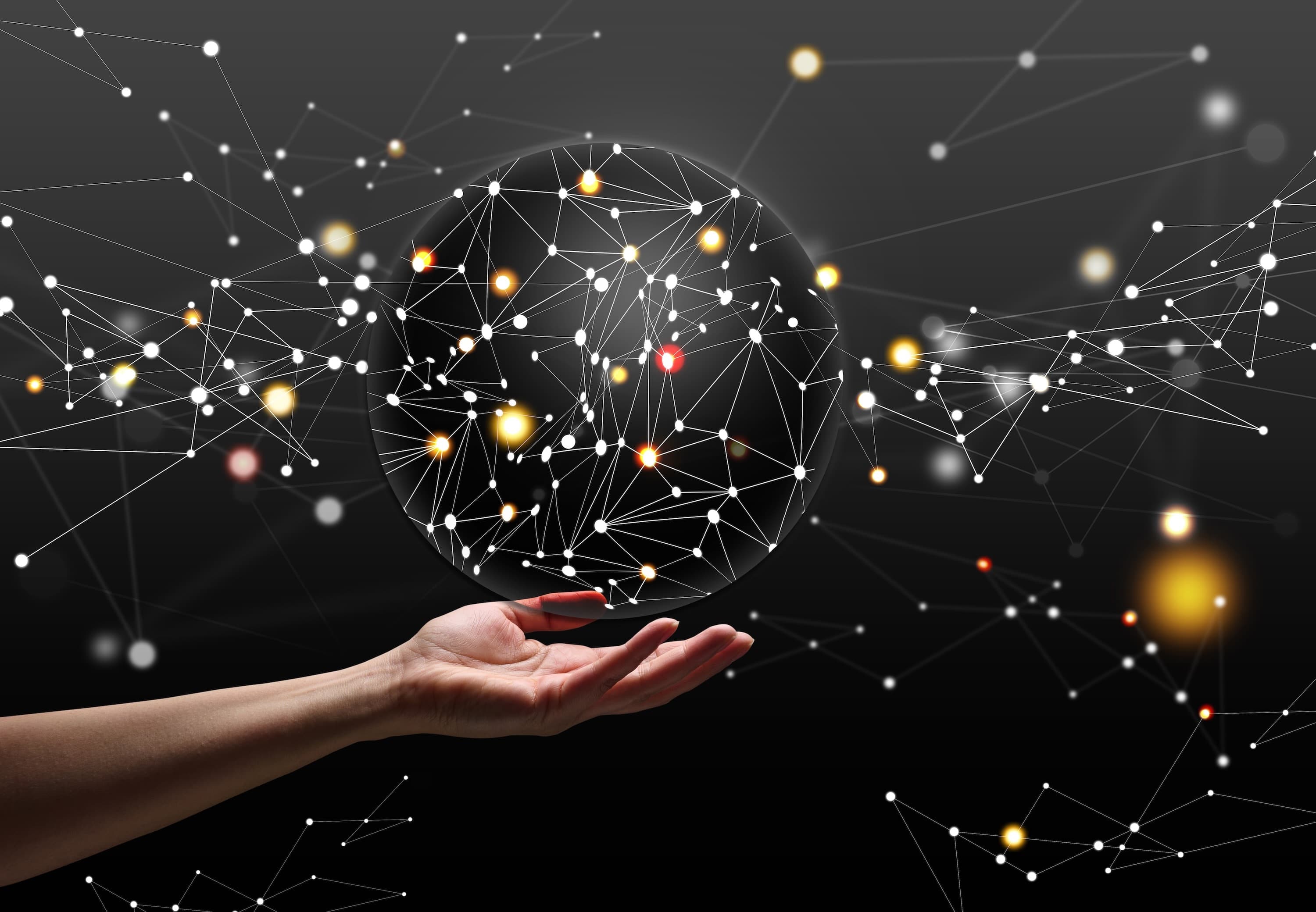 Holding a geometric sphere on dark background with connecting dots.