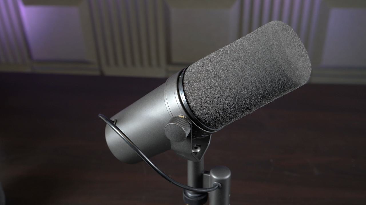 Image shows a Shure SM7B microphone on a desk stand.