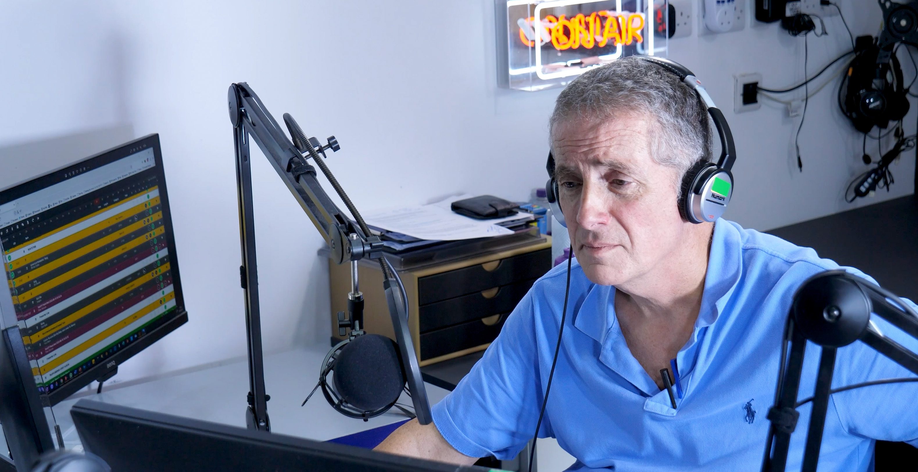 A man on a computer in a radio studio.