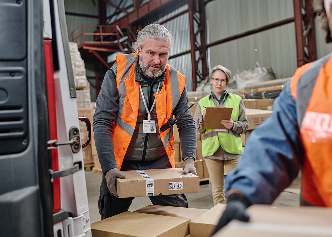 Workers loading up a van with parcels in a warehouse