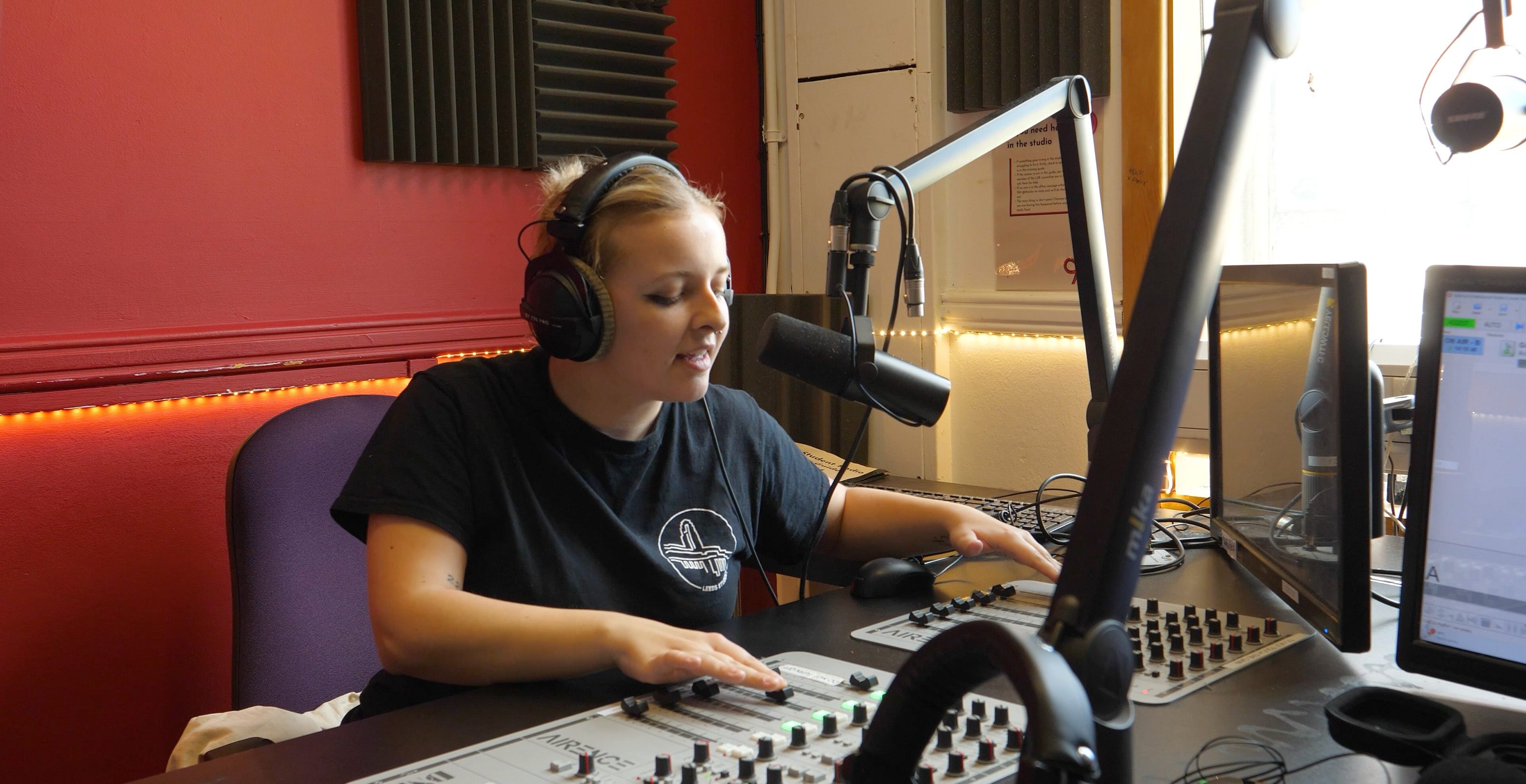 A woman broadcasting in a radio studio.
