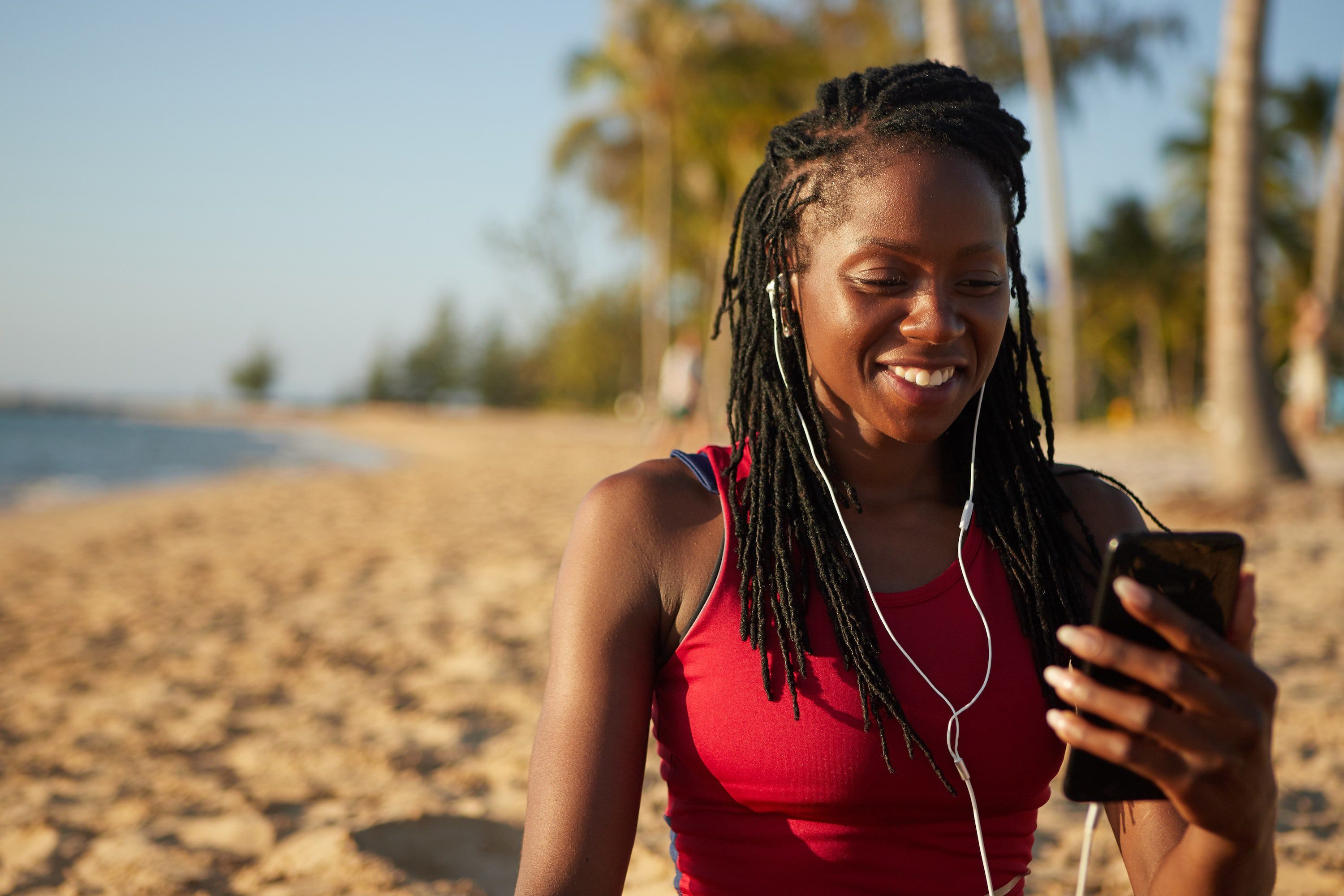 Woman listening to broadcast on her phone on the beach