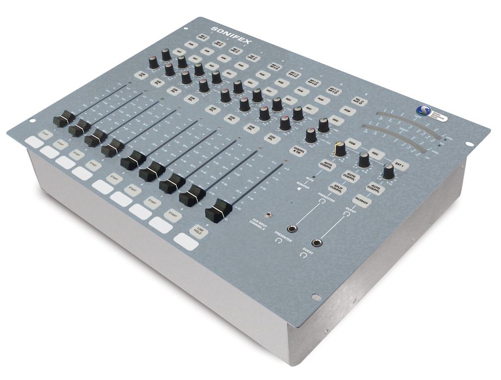 Image shows the grey Sonifex S0 mixing desk, a box style with several faders at the bottom, 2 meters on the right hand side, and various control knobs and buttons.