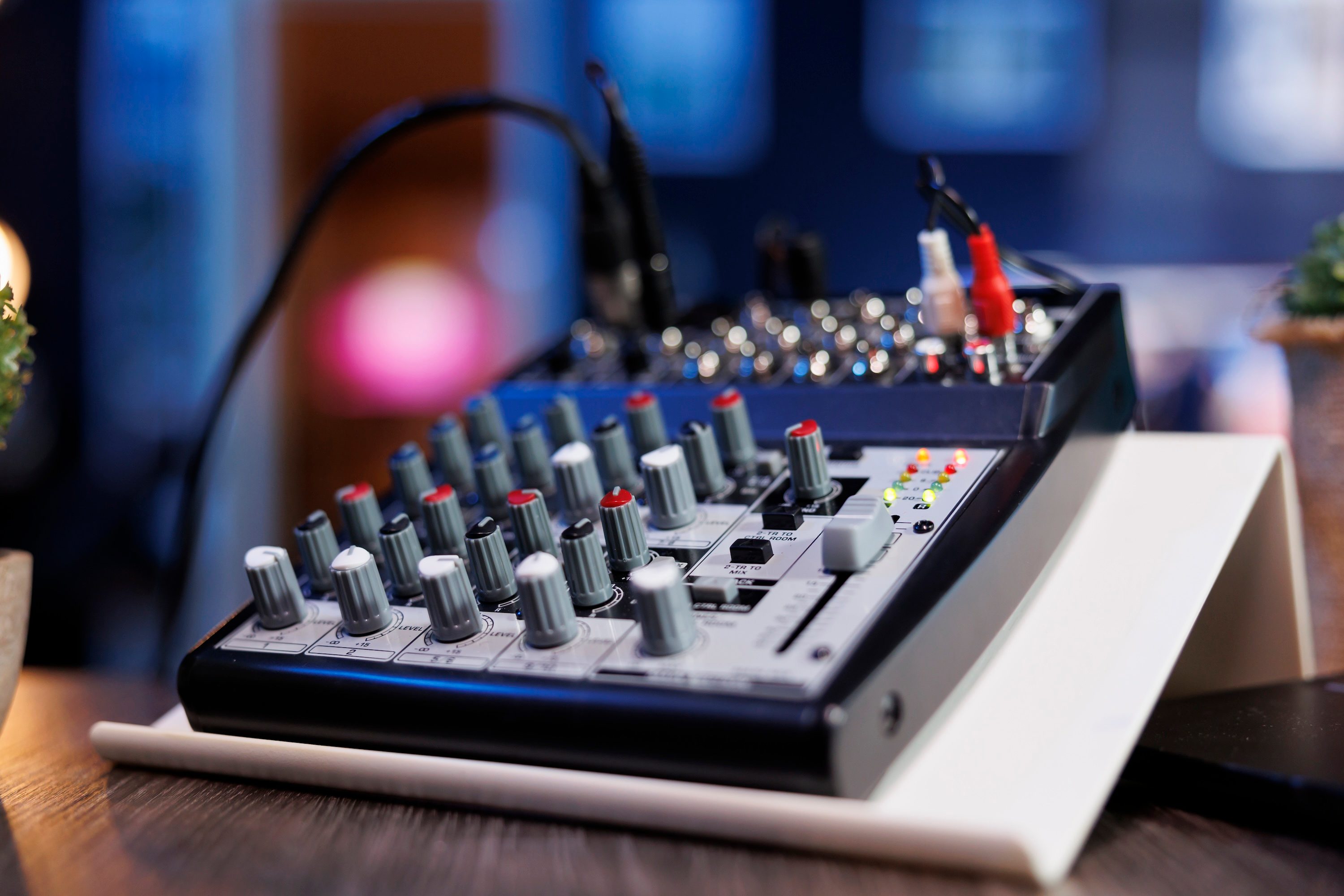 Sound mixer with nods on desk connected to cables.