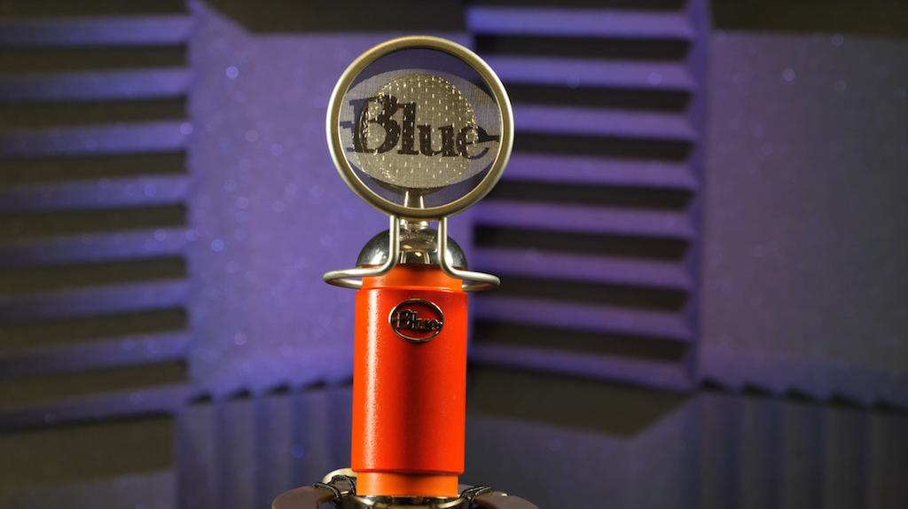 Image shows the Blue Spark microphone spotlighted in a soundproofed studio.