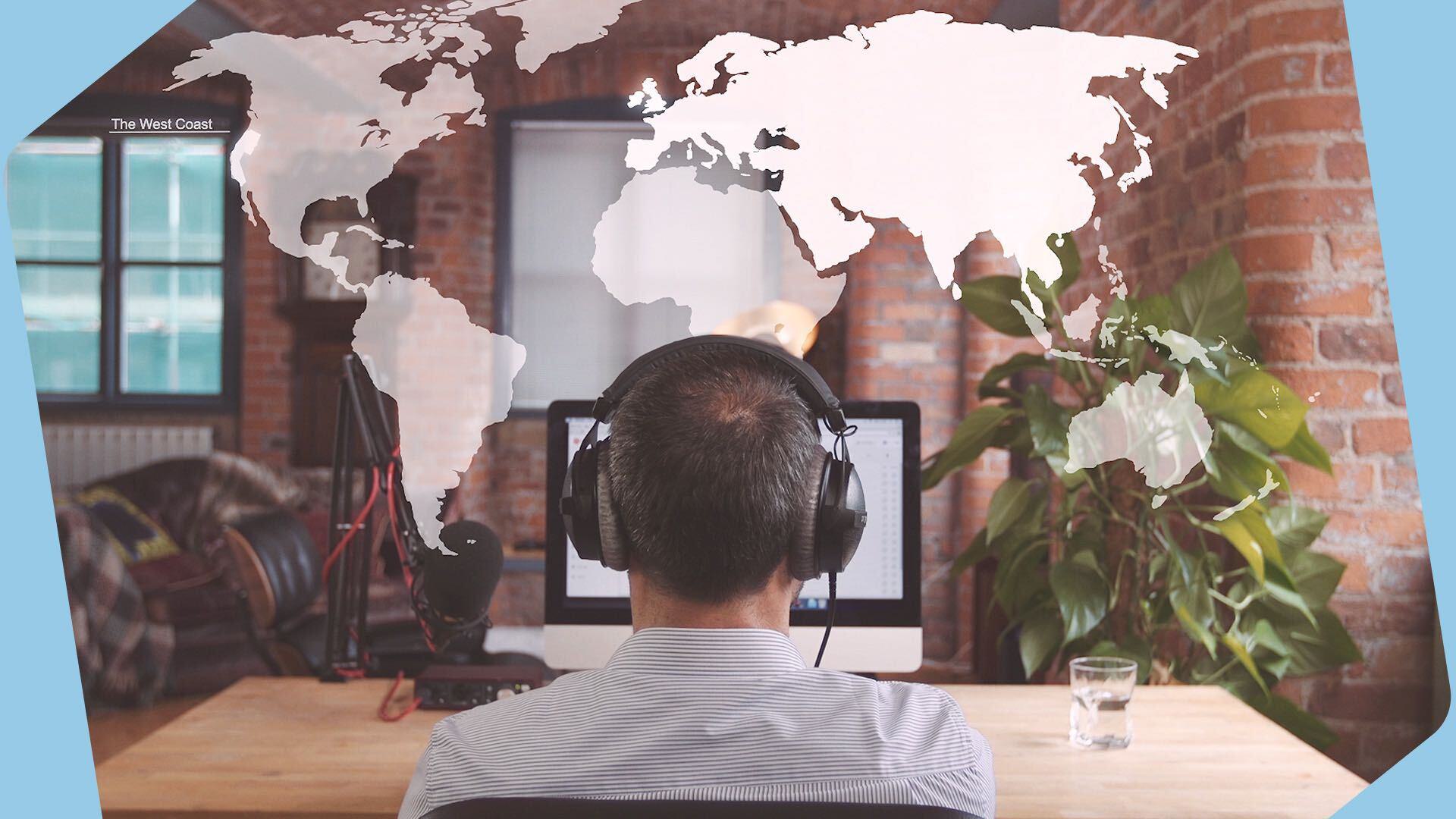 This is an image taken from behind of a man with headphones on looking at a laptop screen. The backdrop is brown with a white overlayed world map above it. The borders of this header image are light blue.
