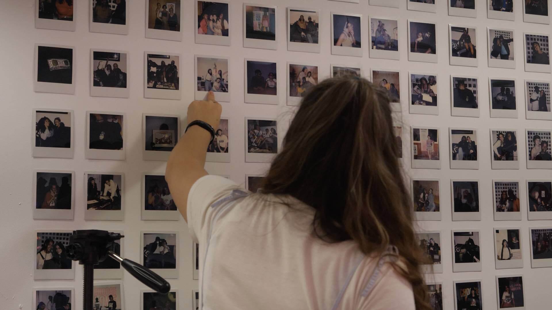 Image shows a wall in the Foundation FM radio studio which has polaroid photos of all their radio hosts.