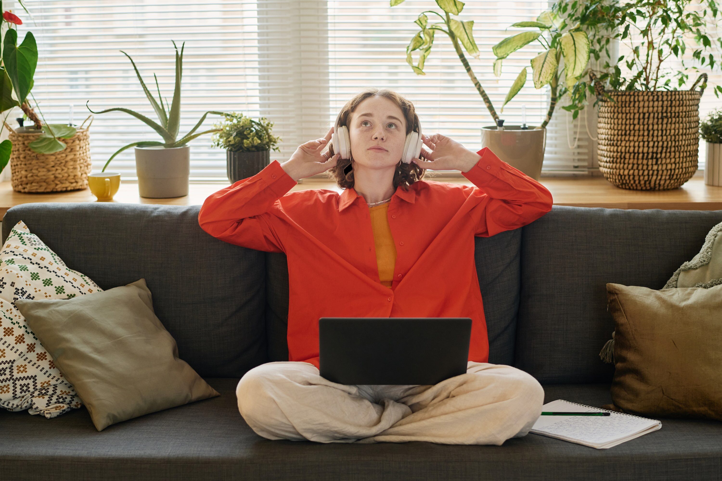 Young woman using laptop and headphones