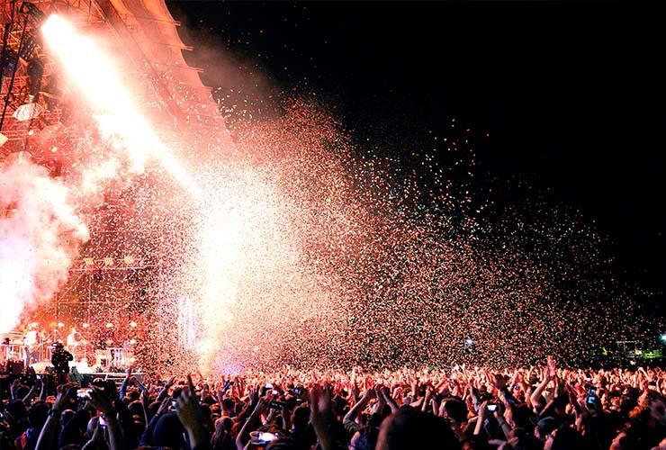 A crowd cheering a band at the Primavera Sound Festival with confetti in the air.