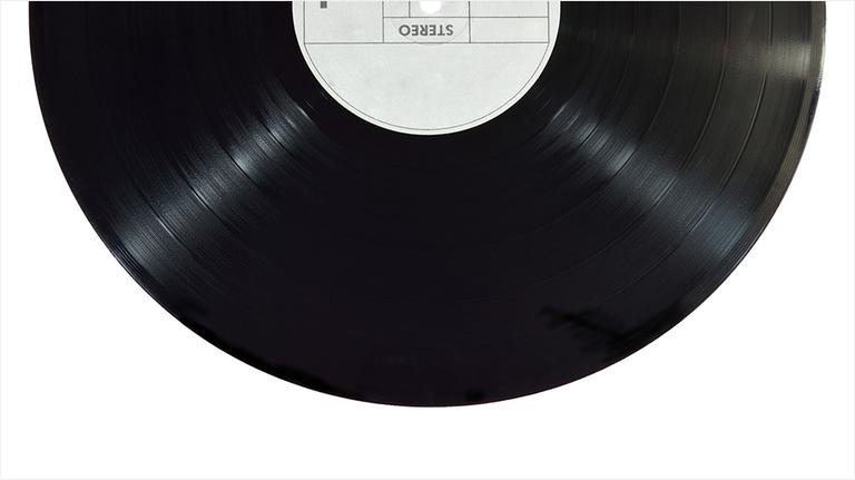 Half of a plain black vinyl record appears as the header image, placed on a white background.