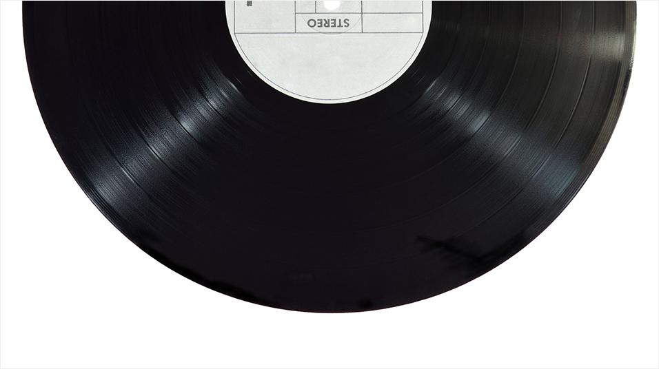 Half of a plain black vinyl record appears as the header image, placed on a white background.