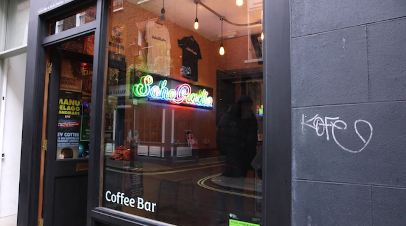 This is an image of the Soho radio studio from the outside, a black building with a neon Soho Radio sign in the window. The rest of the image is blurred.