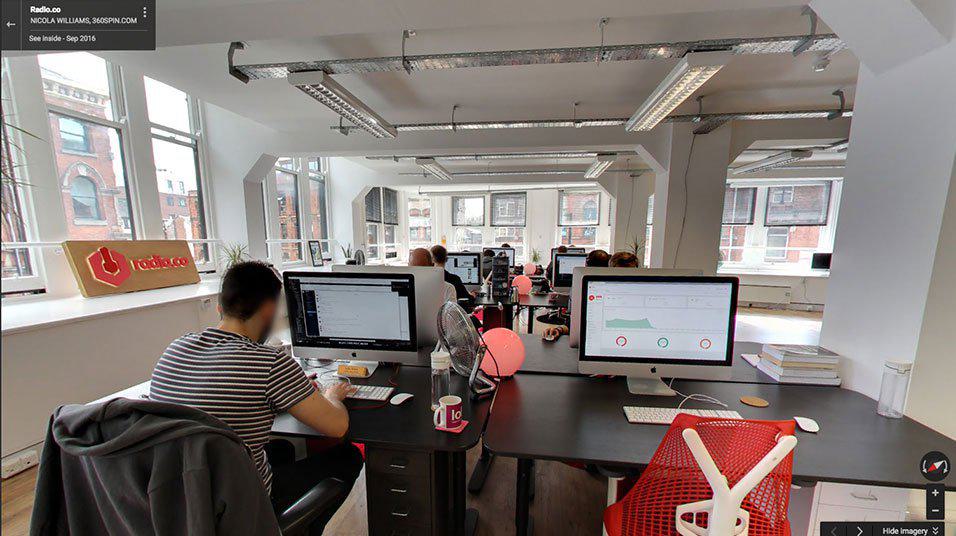 This is a screenshot of the Radiodotco office from Streetview. It is a white open office and features images of the backs of some staff members.