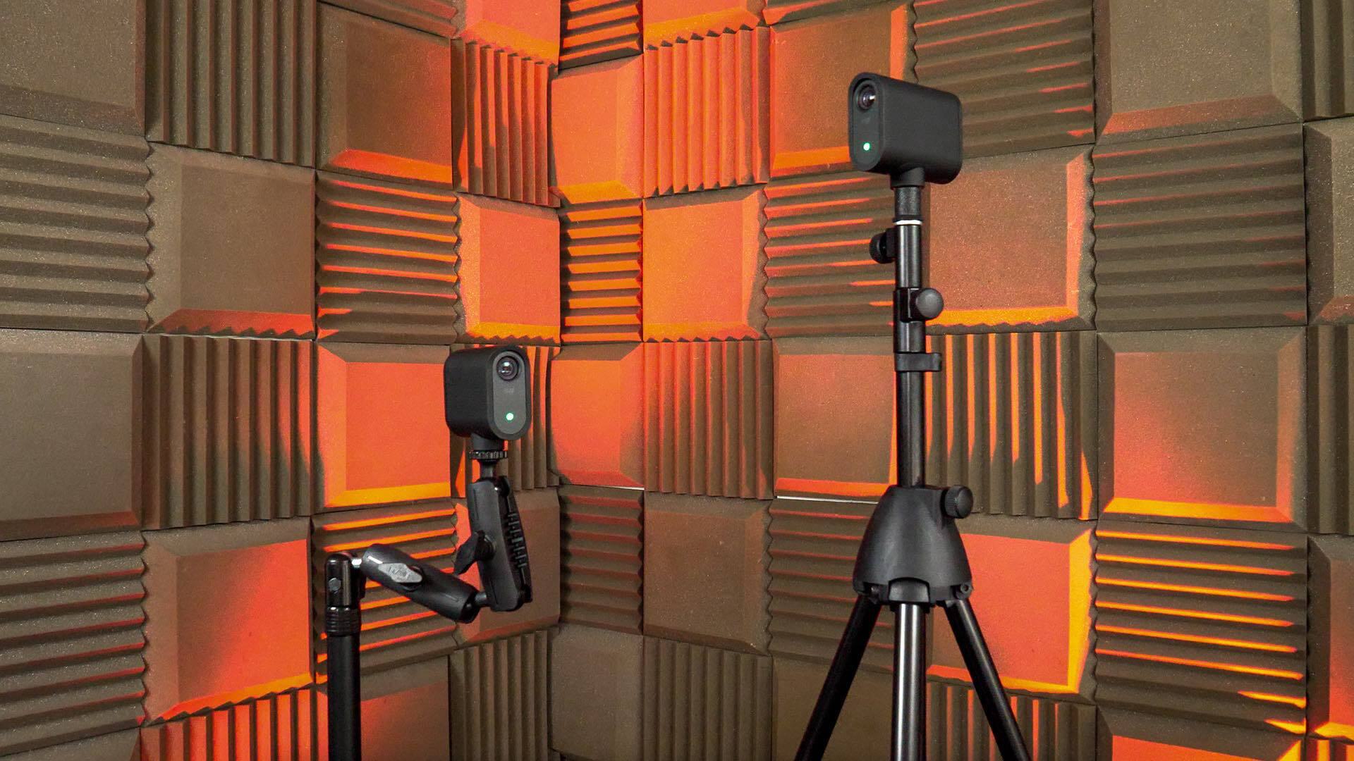 Image shows two Logitech Mevo cameras on stands and pointing towards each other.