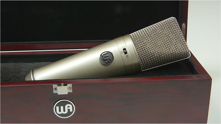 This is an image of a microphone in a wooden box peeking out. The box has a WA sticker on the side.